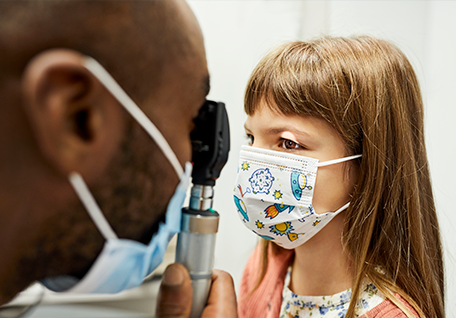Young girl having her eyes examined by a doctor