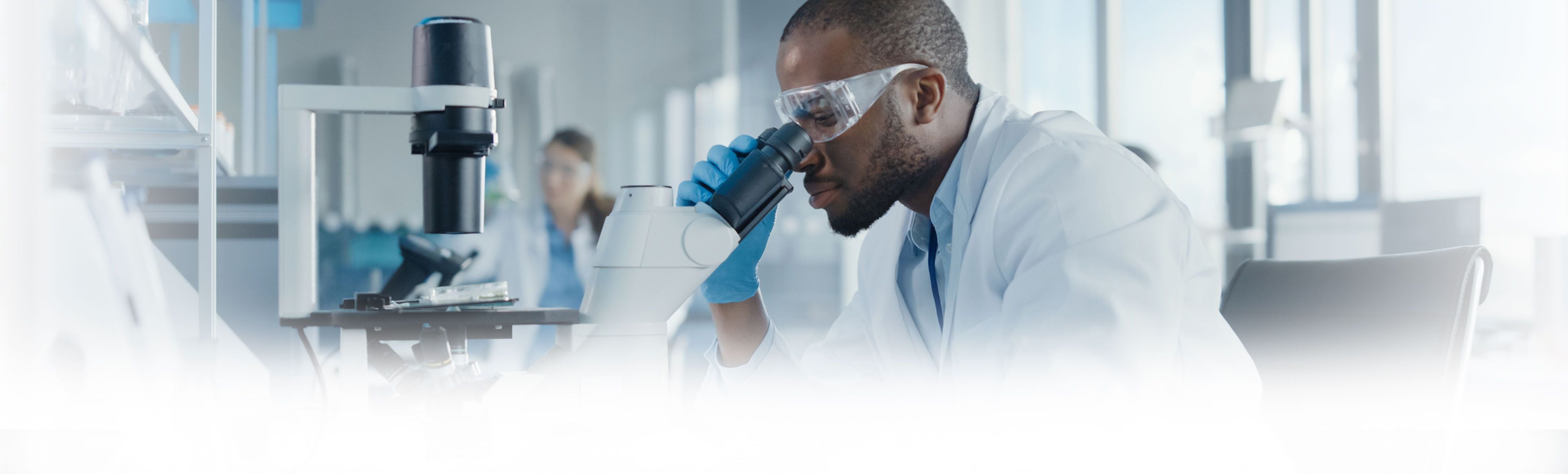 Male researcher looking into microscope 